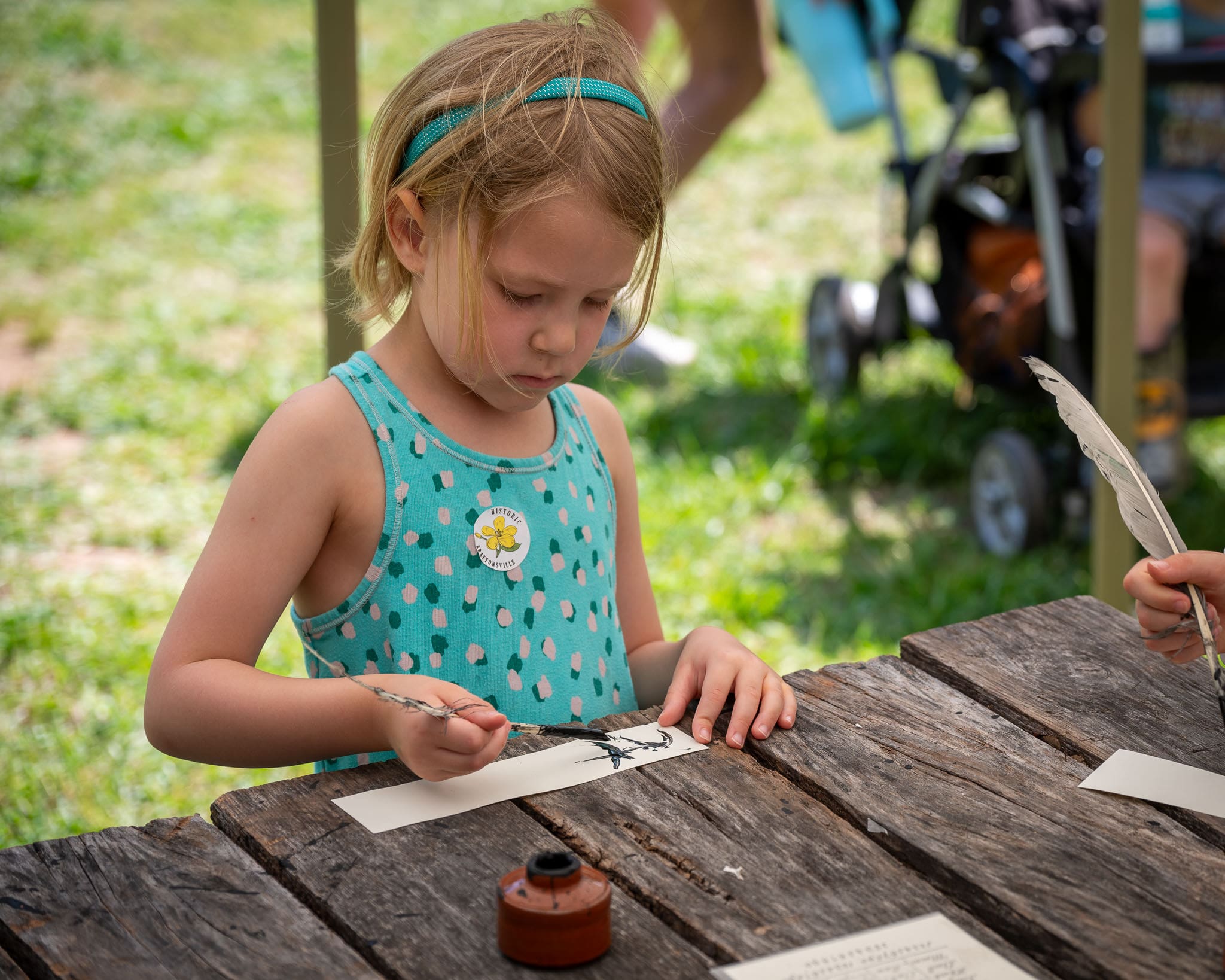 Young girl writing with quill pen